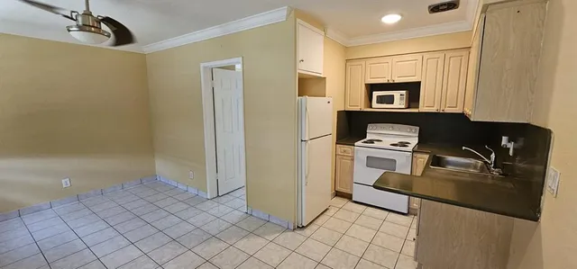 a kitchen with a refrigerator and a stove top oven