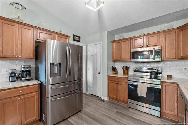 a kitchen with stainless steel appliances granite countertop a refrigerator stove and sink