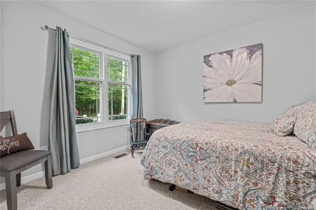 a bedroom with a bed and a painting on the wall