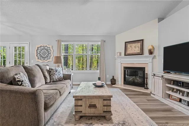 a living room with furniture a flat screen tv and a fireplace