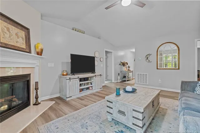a living room with furniture a flat screen tv and a fireplace