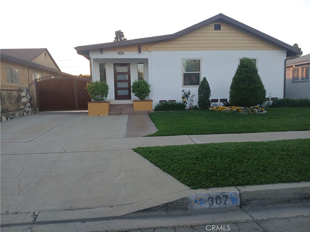 307 North Broadacres Avenue Compton, CA 90220 - Photo 1 of 13 a view of a white house next to a yard and plants