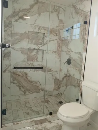 a white toilet next to a shower