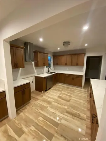 a large white kitchen with a sink a microwave and refrigerator