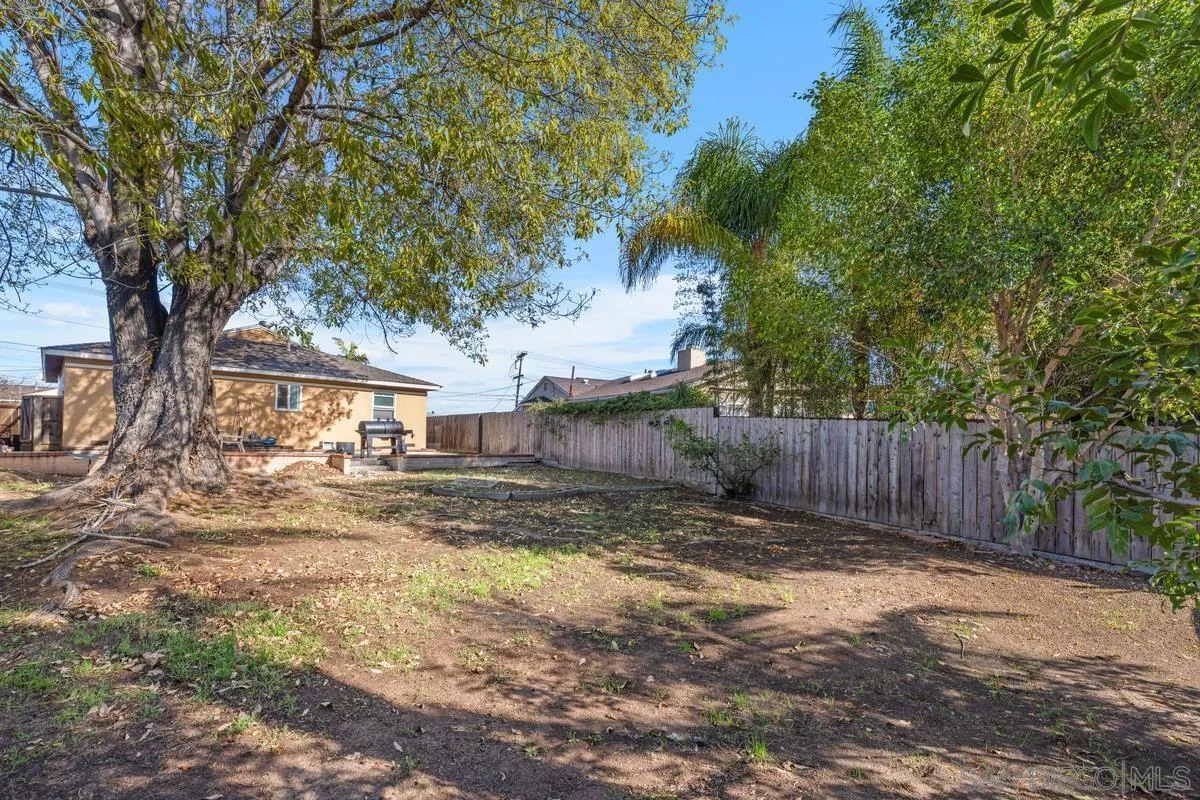 5826 Amarillo Avenue La Mesa, CA 91942 - Photo 20 of 20 a view of a yard with a large tree and wooden fence