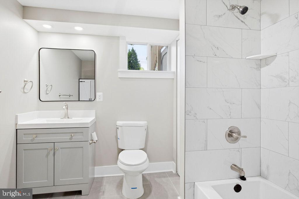 6620 Napoli Road Temple Hills, MD 20748 - Photo 33 of 38 a bathroom with a toilet a sink a mirror a shower and vanity