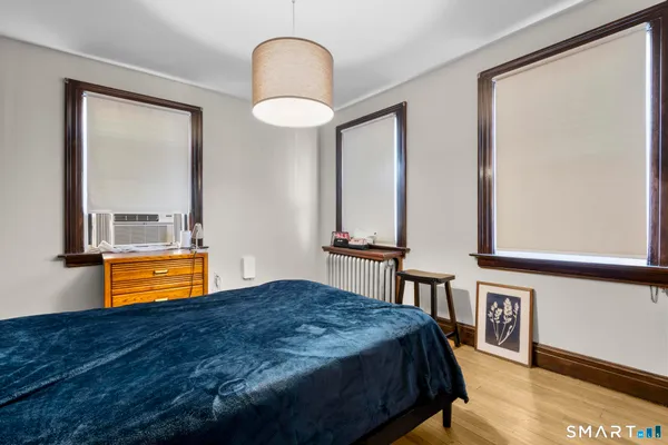 a bedroom with a bed and a painting on the wall