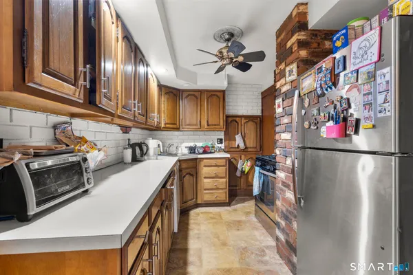 a kitchen with stainless steel appliances granite countertop a refrigerator a stove and a sink with dishwasher