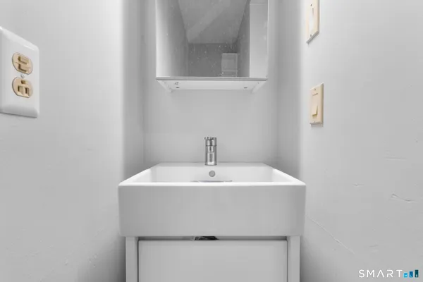 a white toilet sitting next to a white wall