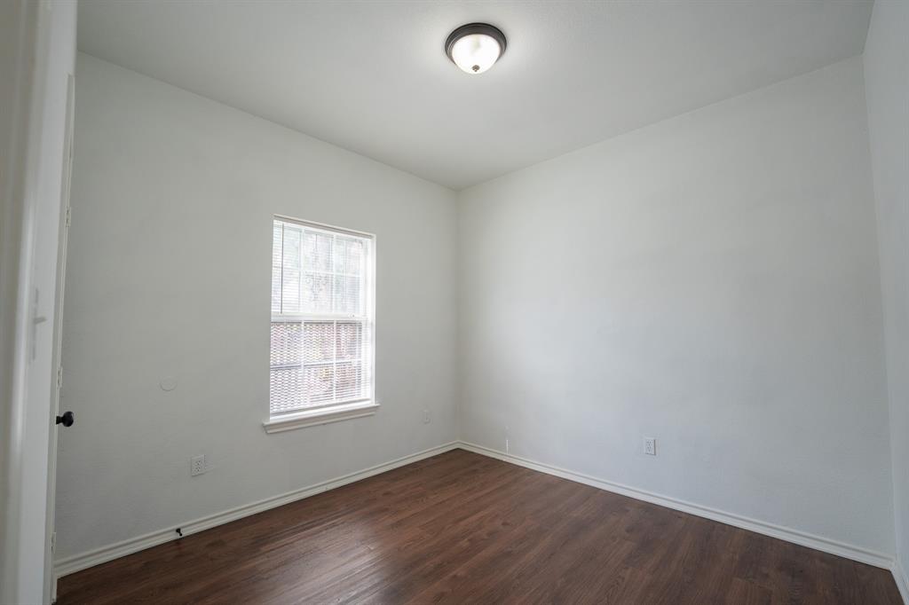 1302 Hendricks Avenue Dallas, TX 75216 - Photo 10 of 12 an empty room with wooden floor and windows