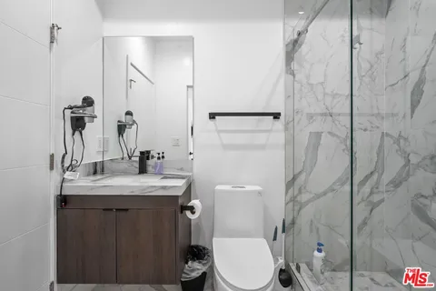 a bathroom with a granite countertop sink toilet and shower