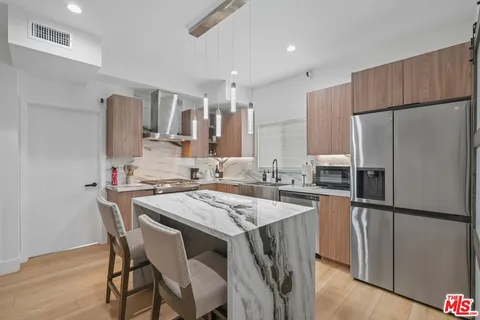 a kitchen with refrigerator a sink and chairs
