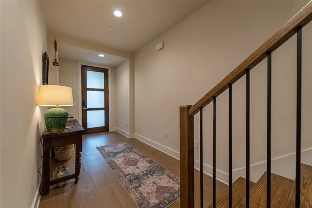 a view of a hallway with wooden floor and a livingroom with couch