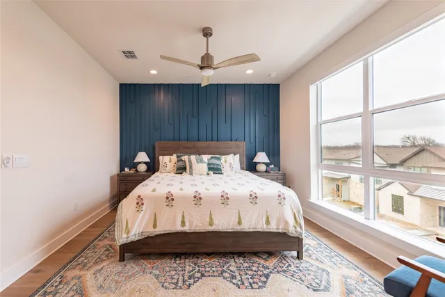 a bedroom with a bed and a large window