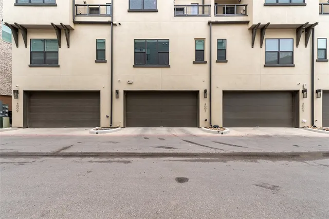a view of a house with a large window and wooden fence