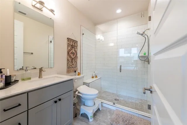 a bathroom with a sink a toilet and shower