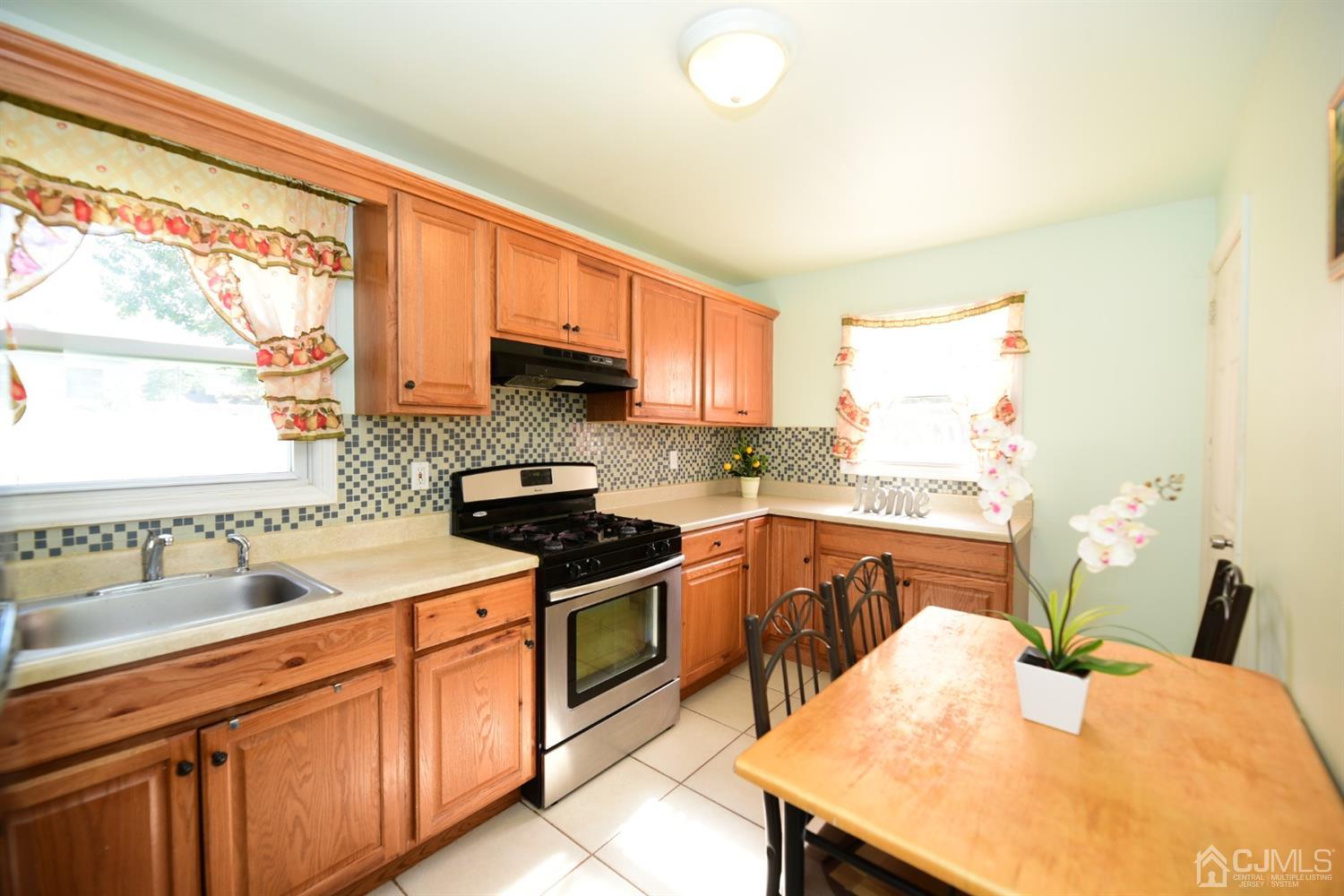 103 Tunison Road New Brunswick, NJ 08901 - Photo 11 of 30 a kitchen with stainless steel appliances granite countertop a sink stove and refrigerator