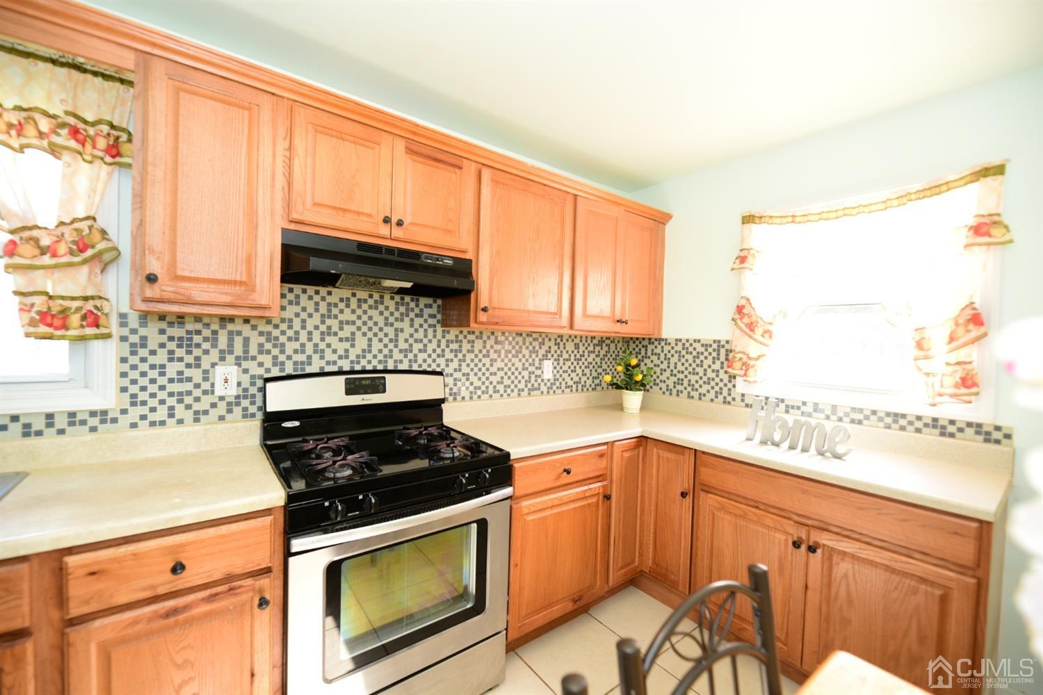 103 Tunison Road New Brunswick, NJ 08901 - Photo 12 of 30 a kitchen with a stove a sink and a microwave