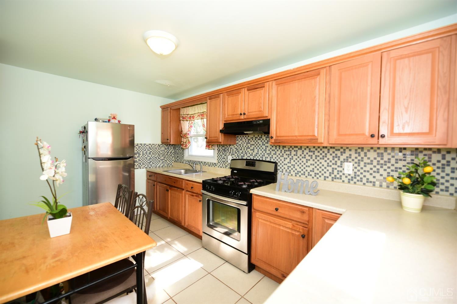103 Tunison Road New Brunswick, NJ 08901 - Photo 13 of 30 a kitchen with stainless steel appliances granite countertop a sink stove and refrigerator
