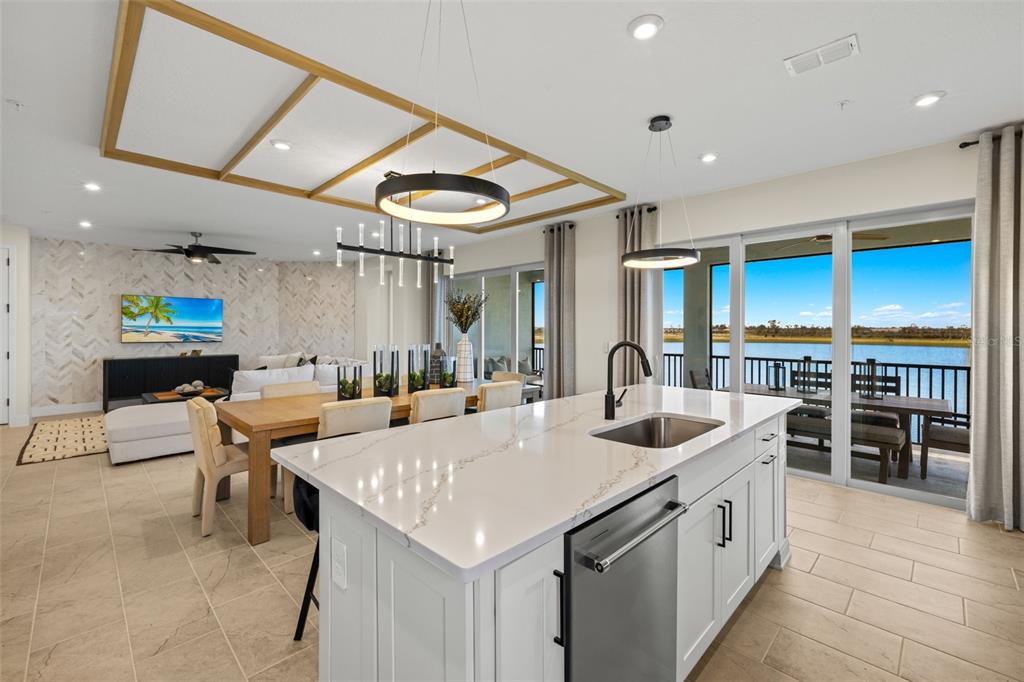 12785 Jade Empress Loop, Unit 202 Venice, FL 34293 - Photo 17 of 42 a kitchen with stainless steel appliances kitchen island granite countertop a sink and cabinets