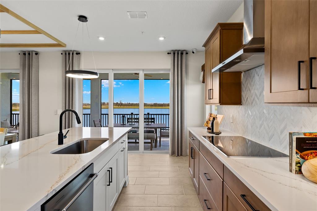 12785 Jade Empress Loop, Unit 202 Venice, FL 34293 - Photo 18 of 42 a kitchen with kitchen island granite countertop a sink stainless steel appliances and cabinets