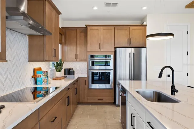 a bedroom with a bed a dresser and a chandelier