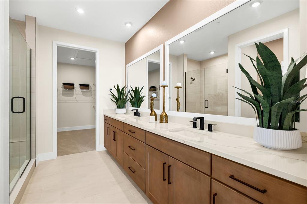 12785 Jade Empress Loop, Unit 202 Venice, FL 34293 - Photo 24 of 42 a bathroom with double vanity a mirror and a shower