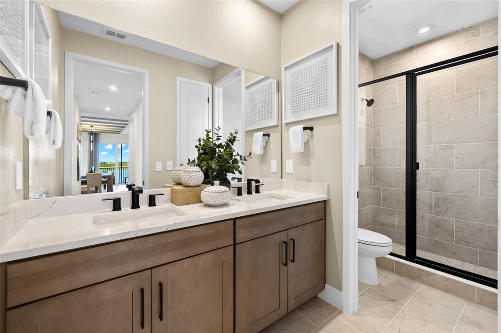 12785 Jade Empress Loop, Unit 202 Venice, FL 34293 - Photo 30 of 42 a bathroom with a double vanity sink mirror and shower