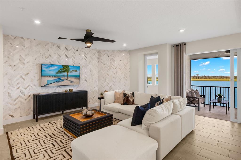 12785 Jade Empress Loop, Unit 202 Venice, FL 34293 - Photo 10 of 42 a living room with furniture a rug and a flat screen tv