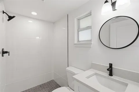 a bathroom with a sink a toilet and a mirror