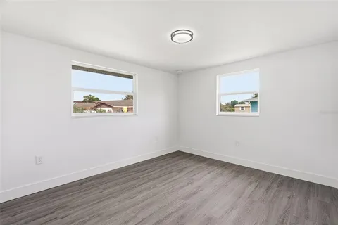 an empty room with wooden floor and window