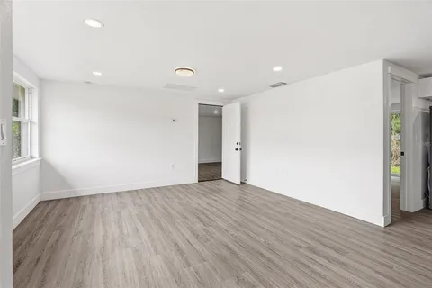 a view of an empty room with wooden floor