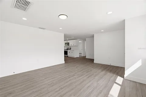 a view of empty room with wooden floor