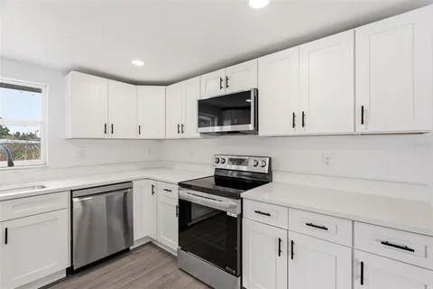 a kitchen with white cabinets and white appliances