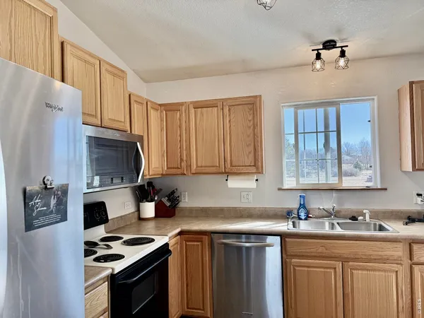 a kitchen with stainless steel appliances granite countertop a stove refrigerator sink and cabinets