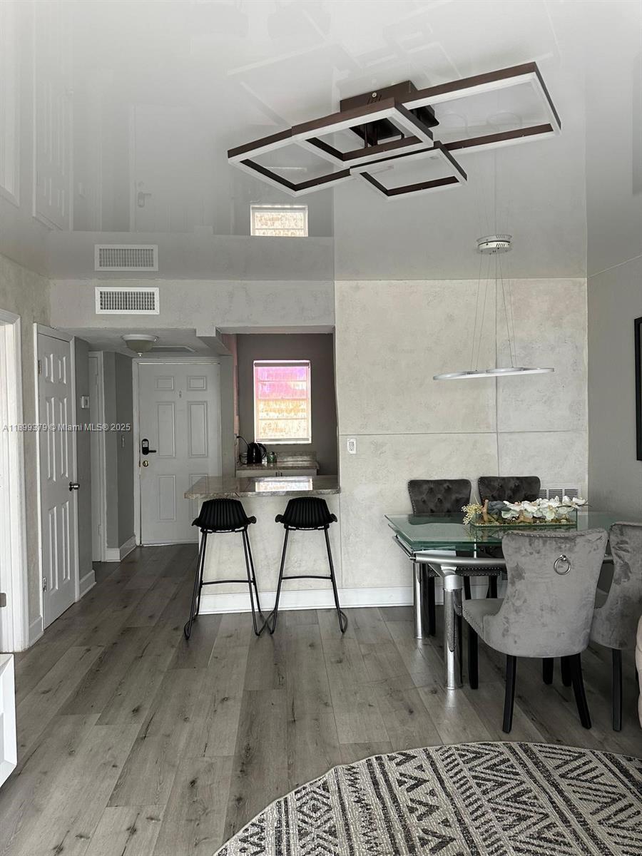 20201 Northeast 29th Court, Unit D335 Aventura, FL 33180 - Photo 2 of 12 a workspace with furniture and wooden floor