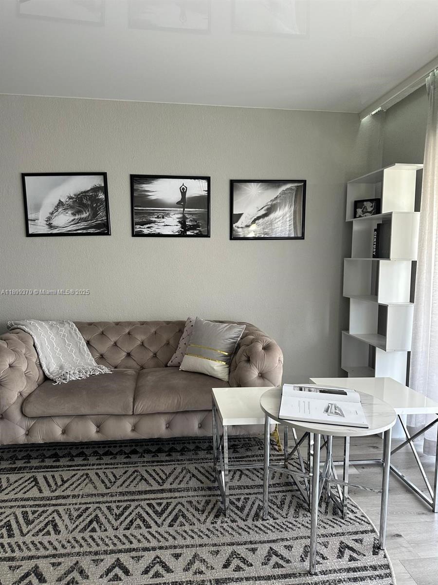 20201 Northeast 29th Court, Unit D335 Aventura, FL 33180 - Photo 5 of 12 a living room with furniture and a rug