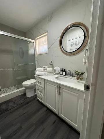 a bathroom with a double vanity sink toilet and a mirror