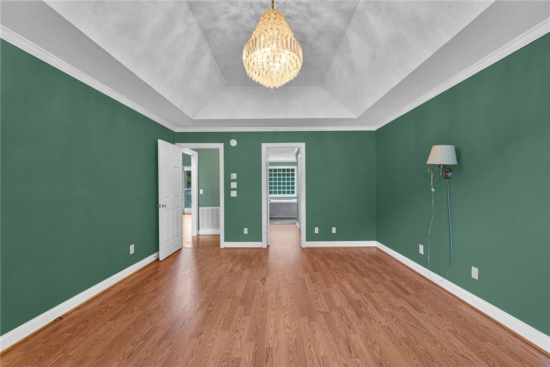 1016 Campbell Road Belton, SC 29627 - Photo 16 of 50 A striking crystal chandelier illuminates the tray ceiling, complementing the rich wood flooring in this inviting space.