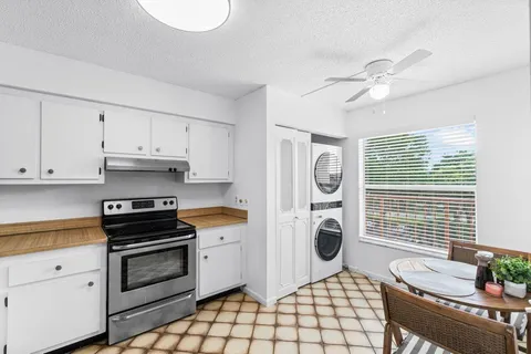 a kitchen with white cabinets and white appliances
