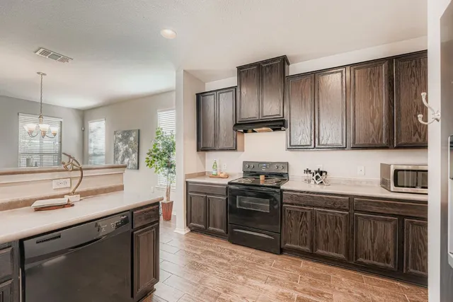 a kitchen with a sink a stove and cabinets