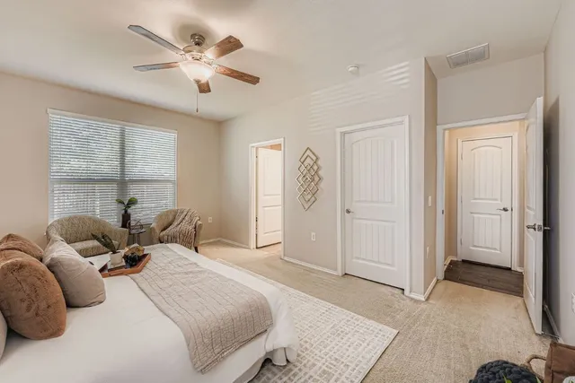 a bedroom with a large bed and a chandelier
