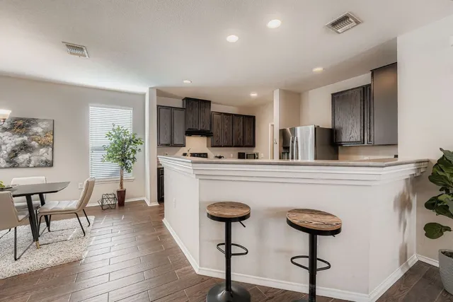 a kitchen with stainless steel appliances kitchen island a refrigerator a stove a sink dishwasher with a dining table and chairs