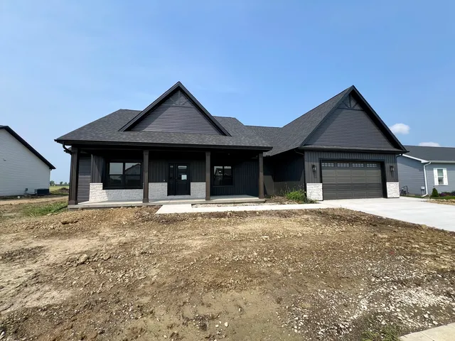 a front view of a house with a garden and yard
