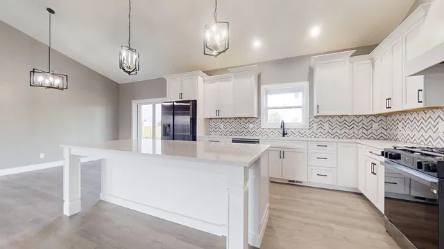 a kitchen with kitchen island white cabinets and stainless steel appliances