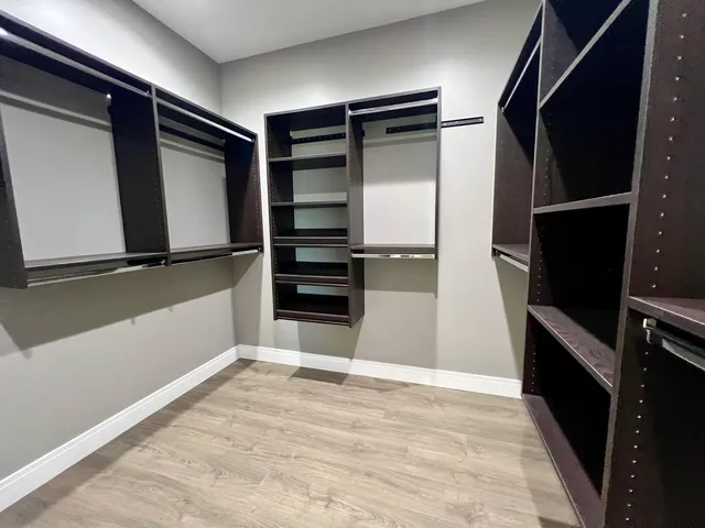 a view of walk in closet with clothes and shoes