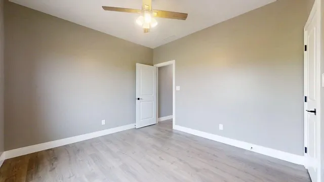 a view of an empty room with wooden floor
