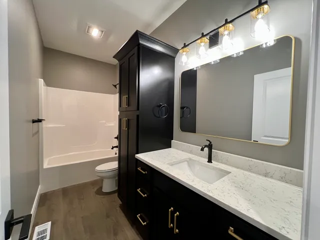 a bathroom with a sink a toilet and shower