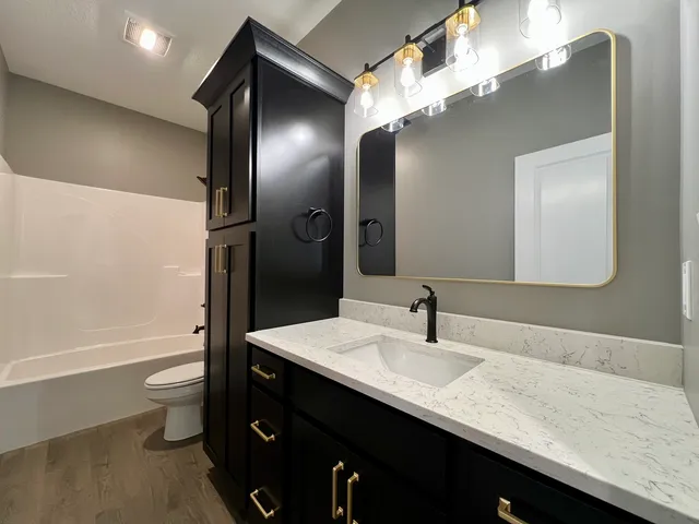 a bathroom with a double vanity sink toilet and shower