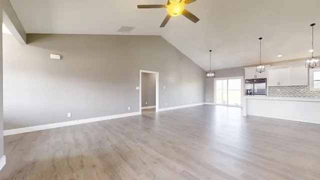wooden floor in an empty room with a kitchen